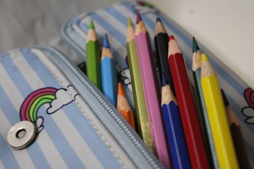 Close-up of colored pencils in a rainbow-themed pencil case.